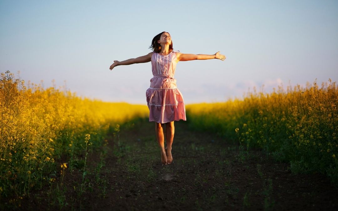 Woman with outstretched hands in nature representing personal growth