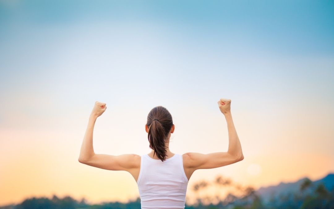 Woman raising arms to show strength representing personal growth