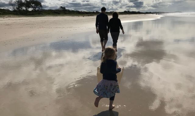Sonya Stattmann walking with family on beach in Australia mobile version