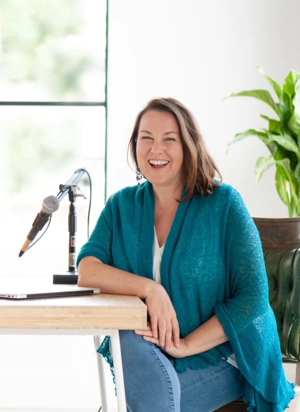 nervous system regulation toolkit sonya stattmann about image of Sonya Stattmann in teal jacket and jeans sitting in front of a microphone recording nervous system regulation tools