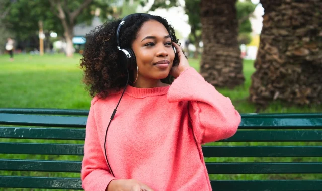 woman sitting on park bench looking out into the distance listening to nervous system regulation tools mobile version