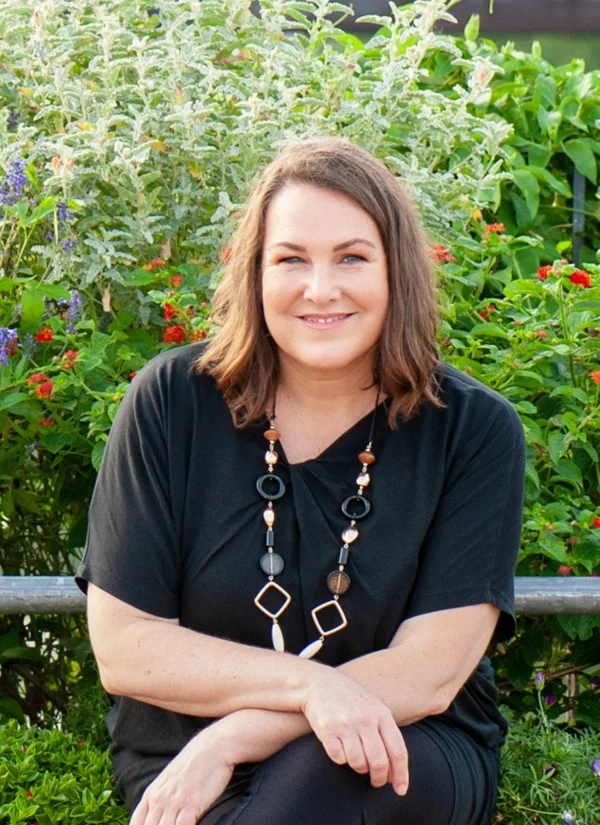 women in business monthly support with sonya stattmann photo of sonya stattmann looking at camera with green bushes all around her