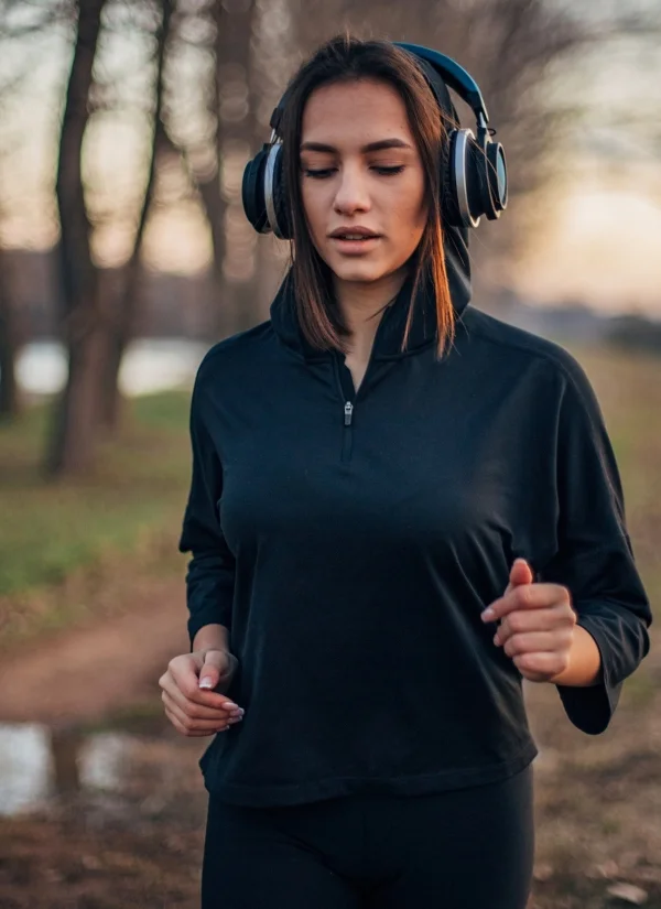 nervous system burnout recovery why audio works woman running in the woods with headphones listening to Burnout Recovery Roadmap